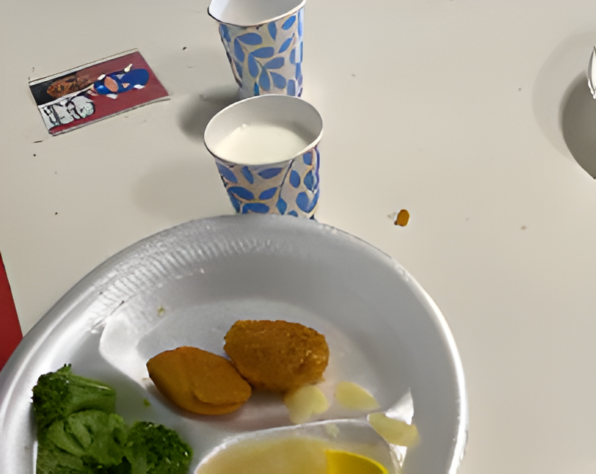 A child's lunch: chicken, broccoli, applesauce and a cup of milk